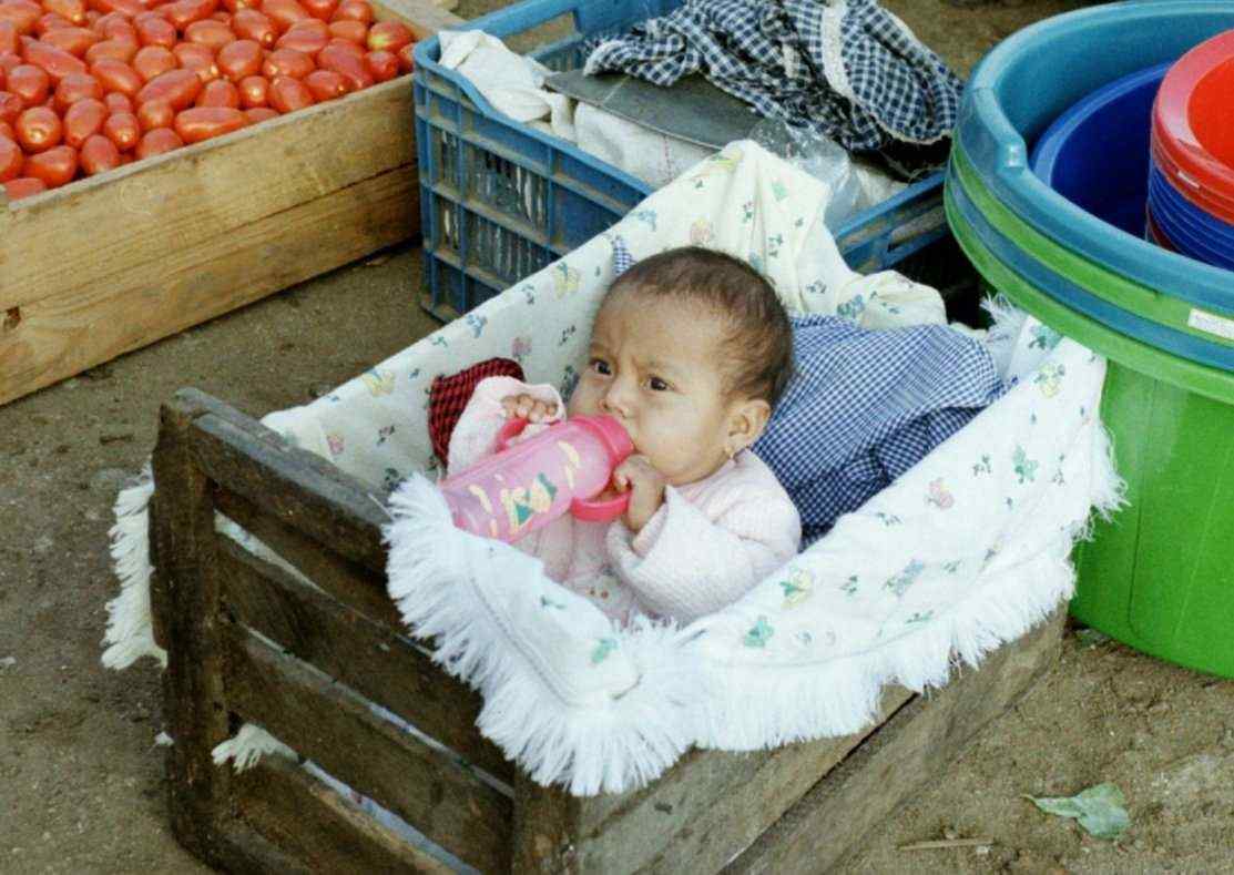 Baby i kasse p morgenmarked i Antigua